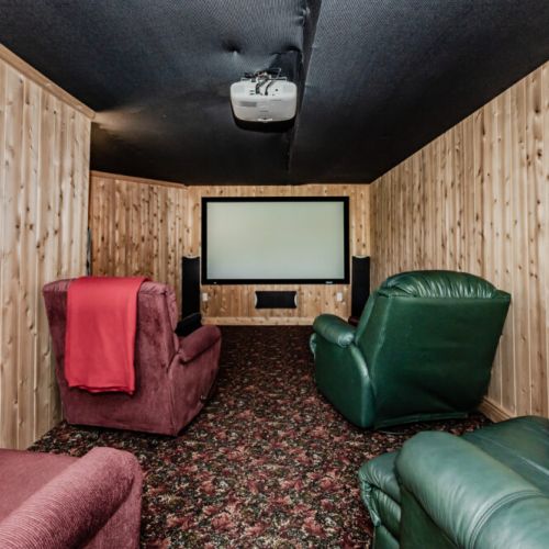 The cozy home theater with rustic wood paneling creates an inviting space for movie nights. Comfortable seating and optimal sound setup provide an immersive cinematic experience just for you!