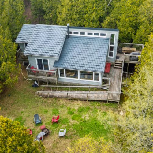 lue Jay Cottage features a spacious wraparound deck, cozy gathering spaces, and a secluded setting surrounded by mature trees.