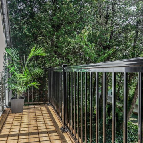 Quiet balcony nook surrounded by trees for a peaceful morning coffee spot.