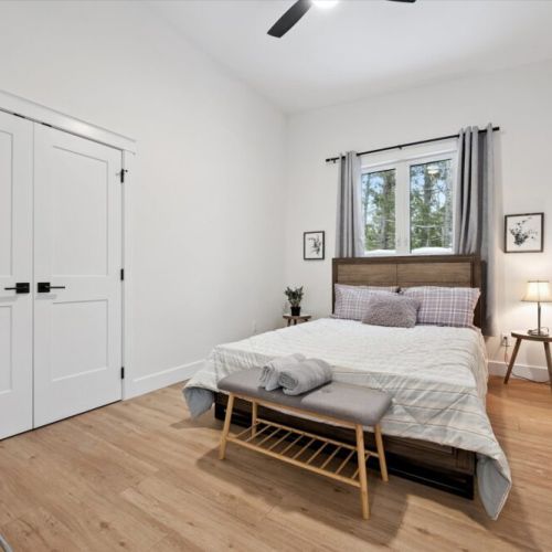 Spacious bedroom with queen bed, bench seating, large closet, and calming natural light.