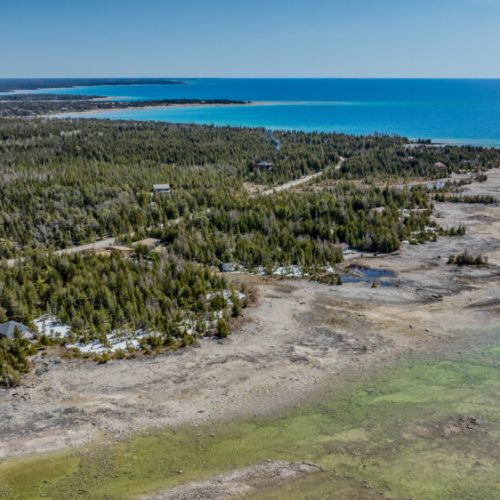 Expansive shoreline and forest views from your cozy cottage getaway, offering breathtaking sunsets and endless outdoor adventure.