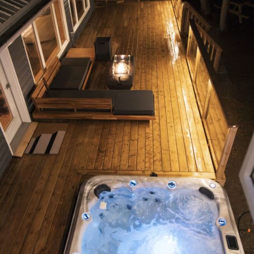 Evenings on the deck: Enjoy a bubbling hot tub, cosy lounge seating, and a glowing fire table—all brought together by warm deck lighting.