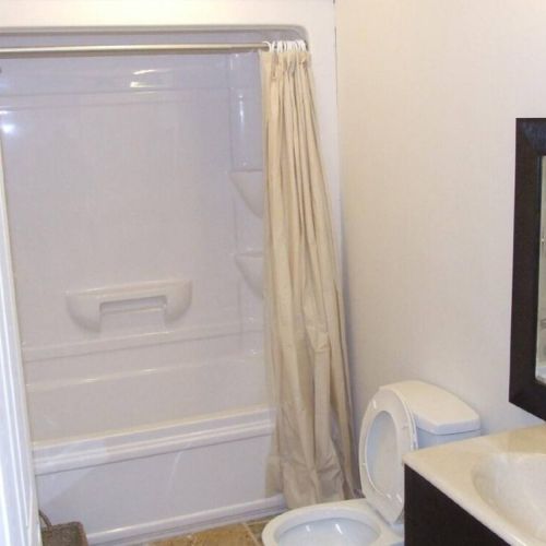 Freshen up in this practical full bathroom with a shower-tub combo, designed for comfort and ease during your cottage stay.
