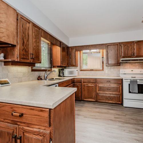 Cook with ease in this warm, wood-accented kitchen featuring full-size appliances, ample counter space, and everything you need for a home-cooked meal.