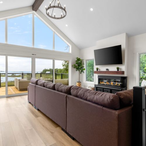 Relax in the bright living room with stunning waterfront views and a cozy fireplace.