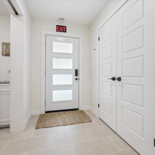 Bright and streamlined, this modern entryway features sleek finishes, minimalist details, and frosted glass for privacy and natural light.