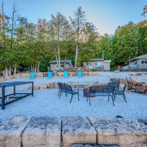 An inviting fire pit setup with Adirondack chairs, offering a picturesque spot to gather around a fire and relax in the evenings.