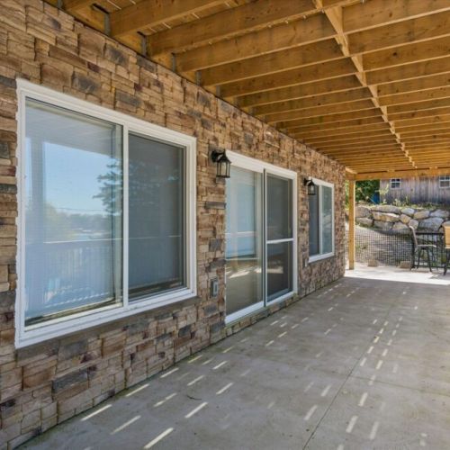 The covered lower patio provides a shaded retreat with easy access to outdoor spaces and waterfront views.