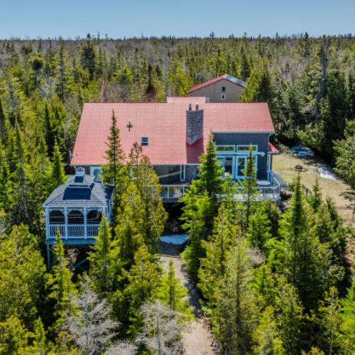 Spacious private lodge surrounded by lush forest, perfect for group getaways and tranquil nature escapes. A unique vacation rental with charming covered decks and scenic views.