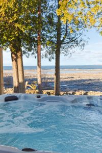 A soak with a view: Settle into the bubbling water and look out across the rocky shoreline to the lake, framed by waterfront trees.