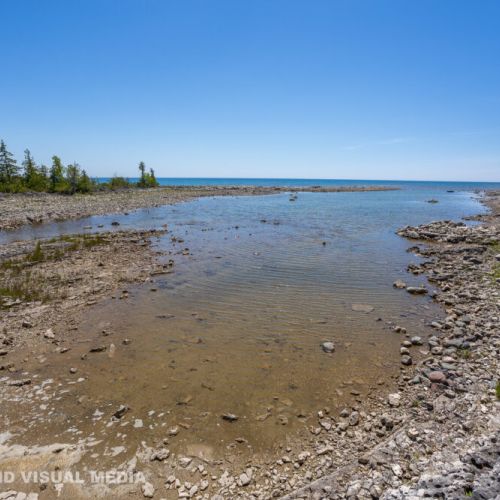 Explore the unique shallow shoreline with crystal-clear water and rugged natural rock formations.