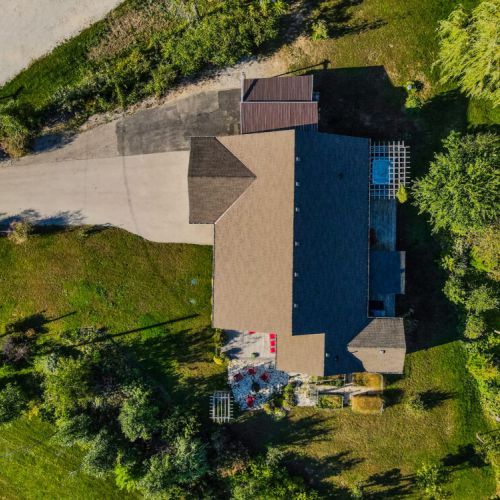 Bird’s-eye view of the property reveals lush landscaping, a private deck, and serene setting—your private escape awaits.