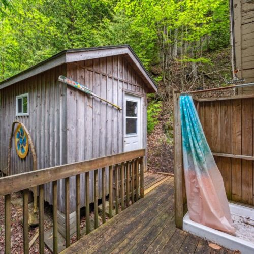 Refresh under the open sky in the charming outdoor shower, surrounded by cedar and birdsong. A nearby outbuilding that serves as a washroom adds rustic flair and cabin charm.