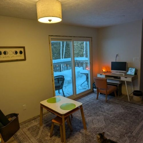 Quiet sitting area with sliding doors leading to the outdoor deck — perfect for morning coffee or relaxing with a book.