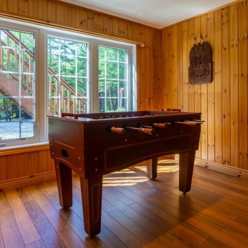 Game on! This foosball room combines rustic charm with playful fun and forest views—ideal for family entertainment indoors.
