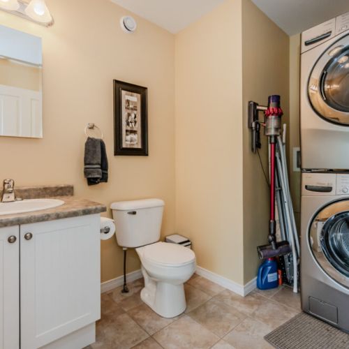 The main floor 2-piece bathroom is both functional and stylish, equipped with a modern washer and dryer.