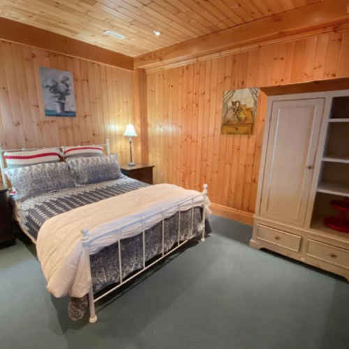 This guest bedroom provides ample space and a serene atmosphere, with simple, elegant decor that invites relaxation.