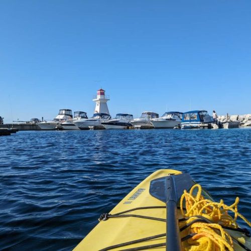 Paddle into adventure! Kayak across calm harbor waters with views of the iconic lighthouse and marina—perfect for water lovers exploring Lion's Head