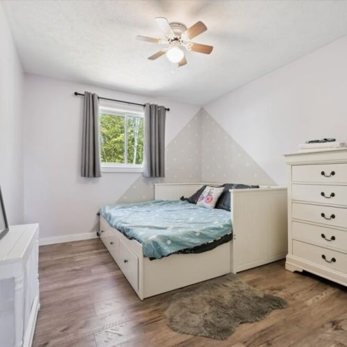 Bedroom 3: A welcoming guest bedroom with natural light, comfortable furnishings, and peaceful woodland views.