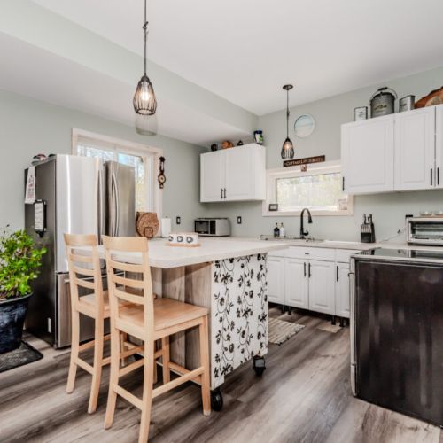 Whip up meals and share stories in this charming country kitchen with island seating—ideal for relaxing family breakfasts and cozy dinners.