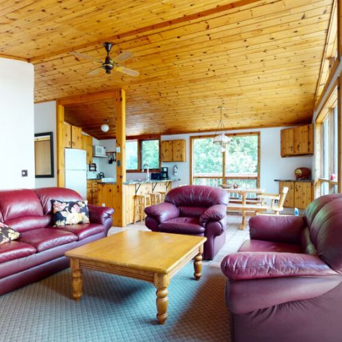 The large living room is cozy and filled with ambiance, with an exceptional view of the water  and access out to the patio.