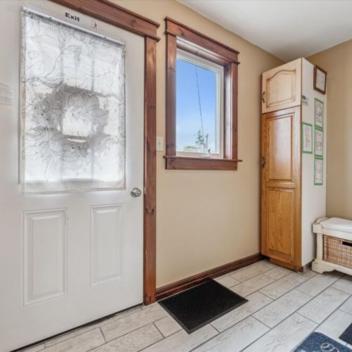 Welcoming entryway with coat hooks, a boot rack, and storage bench—perfect for organizing after a hike or day at the beach.