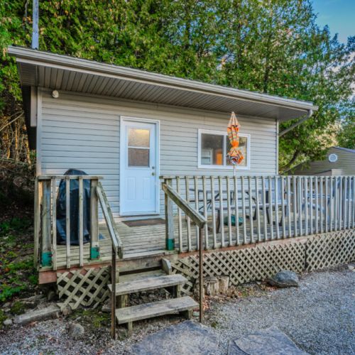 This welcoming entryway has a small deck with steps, offering easy access to outdoor relaxation.