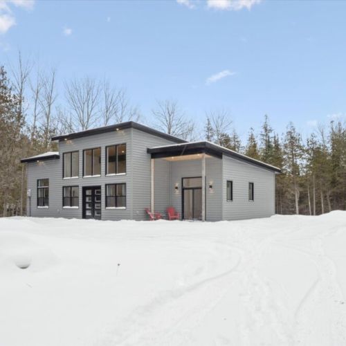 Modern exterior perspective showing clean architecture, outdoor seating, and natural surroundings.