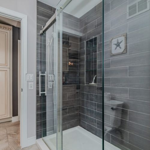 Stylish walk-in glass shower with modern tile—perfect for freshening up after hiking, boating, or beach days at this relaxing retreat.