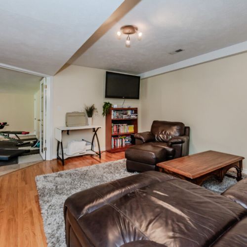 Spacious entertainment lounge with oversized sectional and TV—perfect for streaming, lounging, and spending quality time.