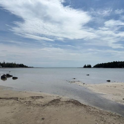 Relax and recharge at this quiet waterfront escape. With soft sand, clear waters, and forested views, it's the perfect spot to unwind and enjoy nature’s beauty.