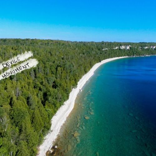 An aerial perspective of Devil's Monument, just a 10 minute drive away, where nature's artistry is on grand display at the edge of crystal waters.