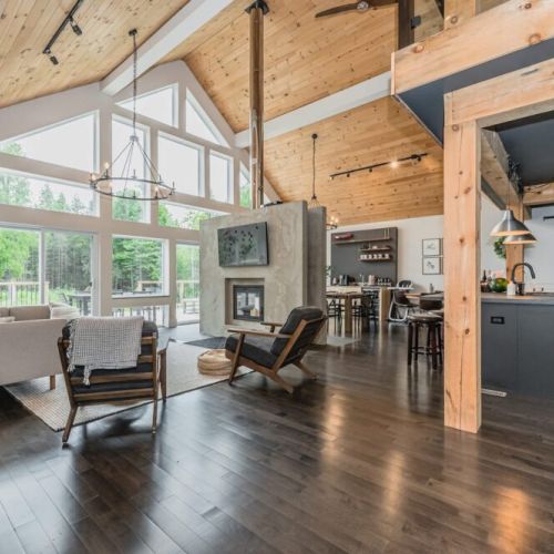 The modern great room provides easy access to. the open concept kitchen, main floor bedrooms and more.