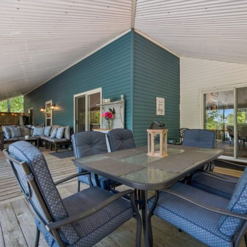 Spacious covered deck with outdoor dining and lounge seating — perfect for meals and relaxing outdoors.