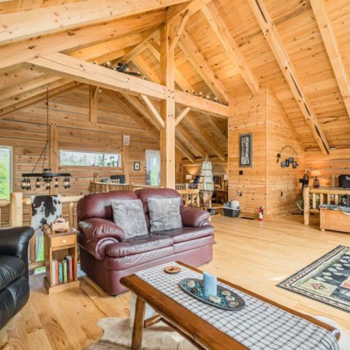 The expansive loft living area features comfortable seating, handcrafted furniture, and ample natural light, creating a welcoming and serene environment.