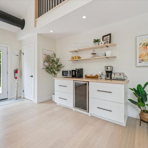 Thoughtfully designed for convenience and charm — this coffee and beverage station features open shelving, a mini fridge, and everything you need to sip, snack, and unwind.