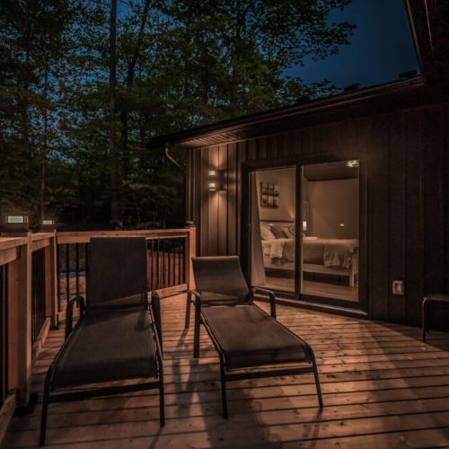 A nighttime view of the deck's seating area, highlighting the cozy ambiance and connection to the master bedroom.