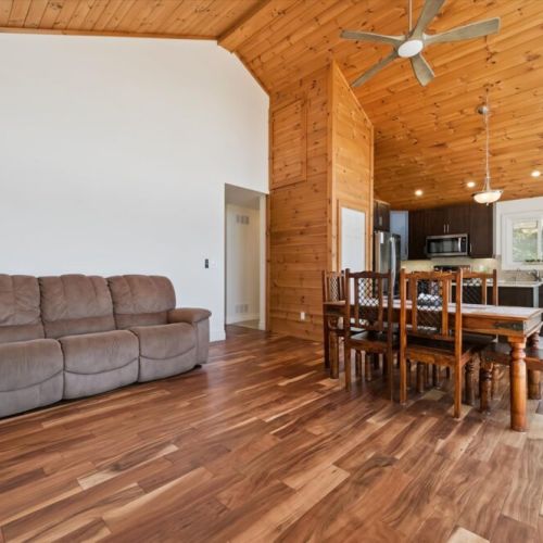 The bright, open-concept living and dining area features soaring cathedral ceilings and plenty of space for gathering together.
