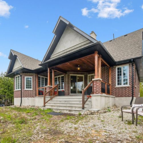 The charming back entrance welcomes guests with classic architecture and spacious outdoor living areas.