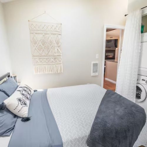 The primary bedroom with a queen bed, cozy linens, and direct access to the outdoors through a sliding door.
