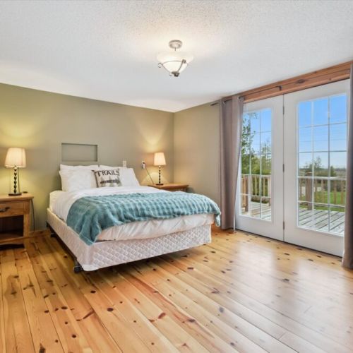 Bedroom 1: Bright and comfortable queen bedroom with walkout to the deck