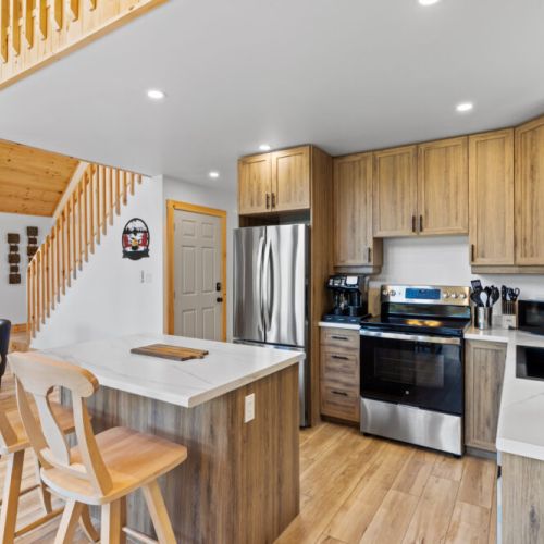 The fully equipped kitchen features modern appliances, a spacious island, and everything needed to prepare meals.