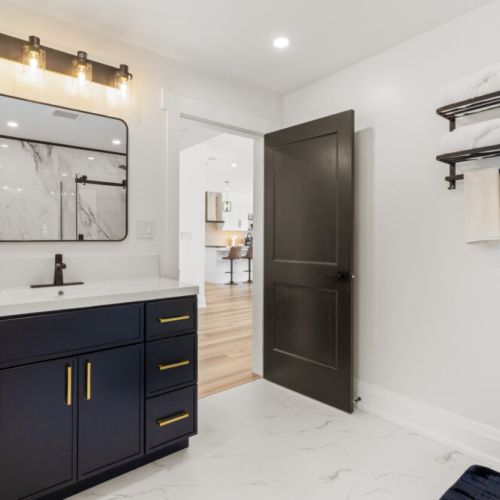 Another view of the stylish bathroom showcasing its modern vanity and bright design.