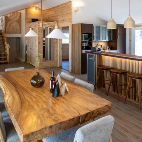 Gather around the dining table and enjoy a delicious meal in this cozy and inviting space. The warm glow of the fireplace and the soft ambient lighting create the perfect atmosphere for relaxation and conversation. The open-concept design allows for seamless flow between the dining area, living room, and kitchen.