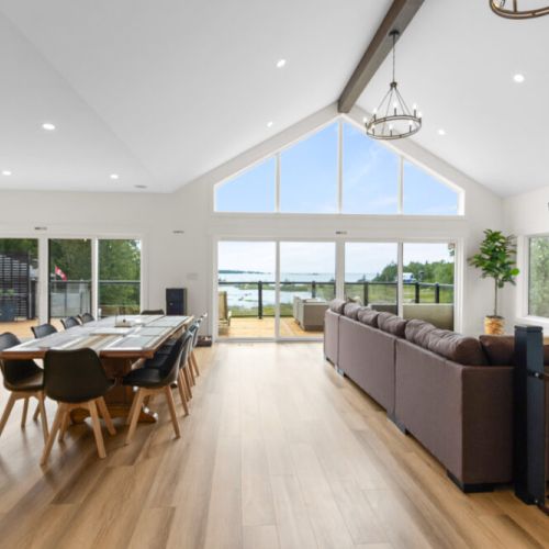 The bright, open-concept living space is designed for gathering, dining, and taking in the waterfront views.