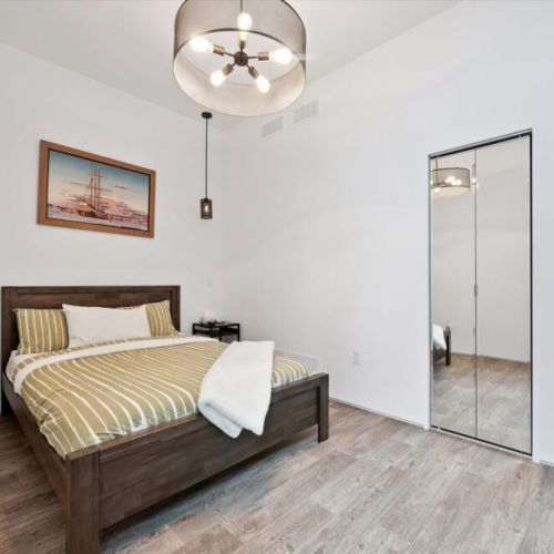 A peaceful bedroom with warm wood tones, modern lighting, and a clean, minimalist feel that encourages deep rest.