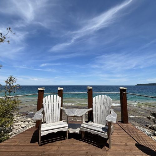 Beeshore invites you to relax on the cozy deck overlooking breathtaking lake views. Enjoy the serene atmosphere with comfortable seating perfect for unwinding.