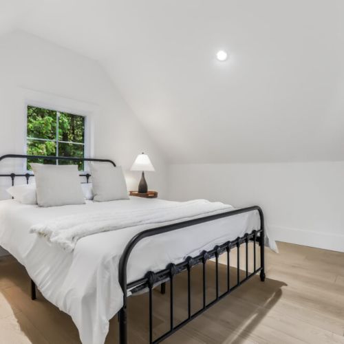 Loft bedroom with a comfy bed and peaceful treetop views for a great night’s sleep.