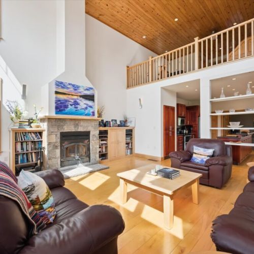 Inviting living room with cozy fireplace and dramatic cathedral ceilings.