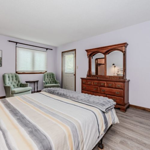 Unwind in a cozy, spacious bedroom featuring plush seating, vintage decor, and private access to outdoor adventures. Perfect for your relaxing cottage getaway